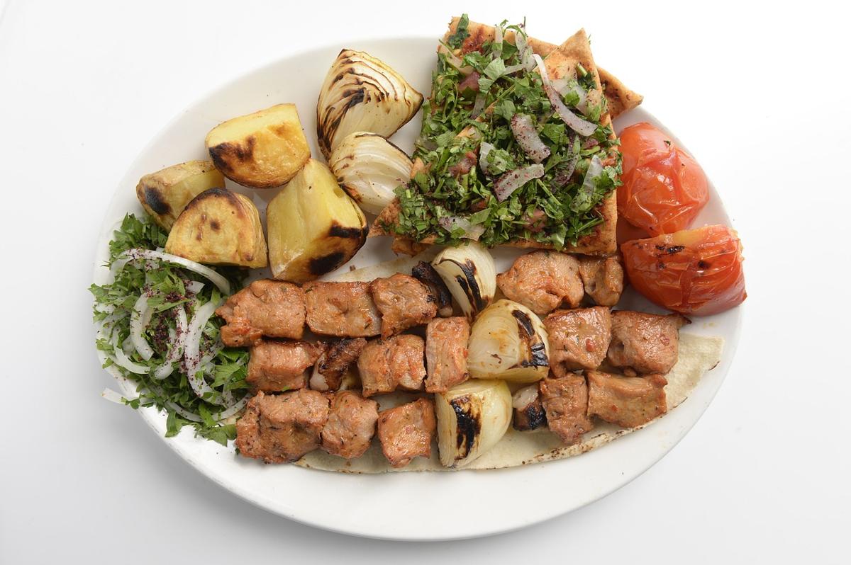 A healthy Pakistani meal plate with grilled chicken tikka, fresh salad, and mint chutney