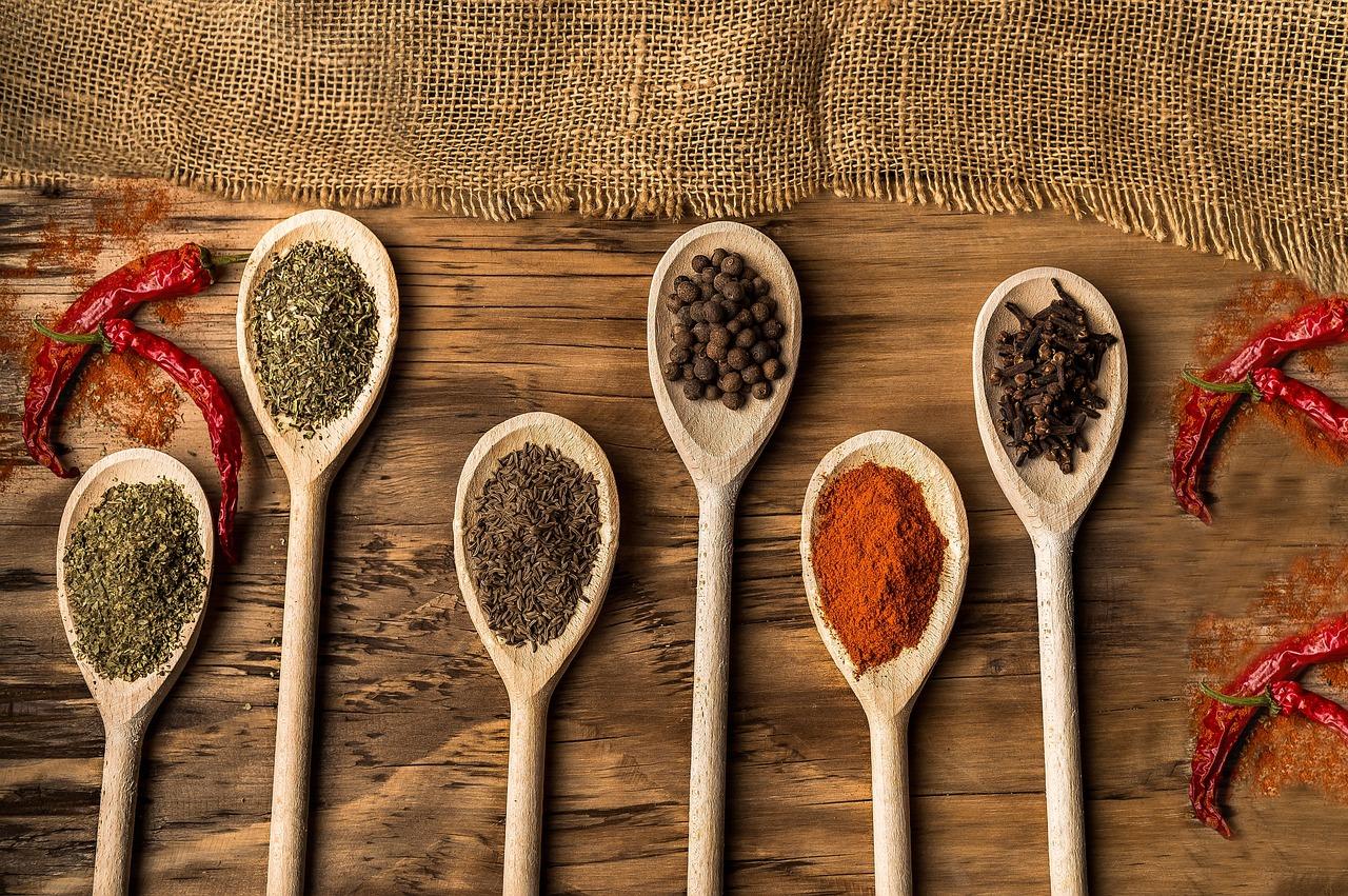 Traditional dried herbs, spices, and wooden spoons arranged on a rustic surface