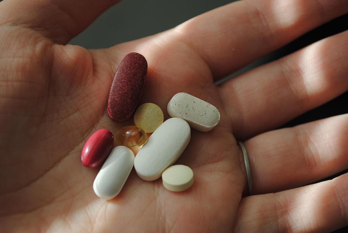 Nutritional supplement bottles placed beside fresh eggs, nuts, and a glass of milk