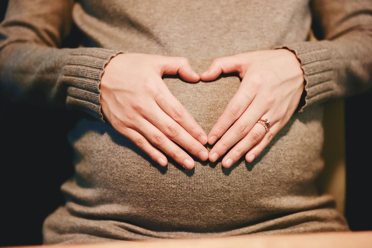 An expectant mother sitting comfortably taking notes in a personal journal