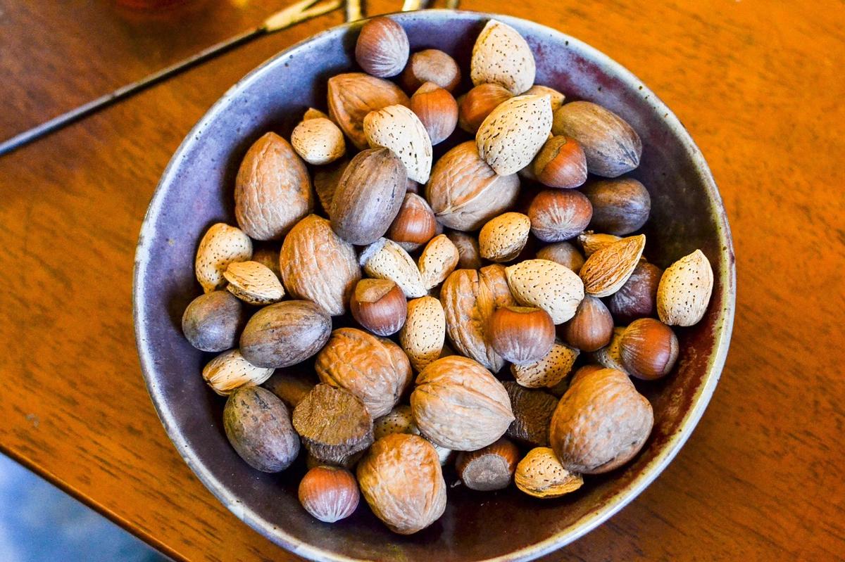A small handful of mixed almonds, walnuts and pistachios being measured