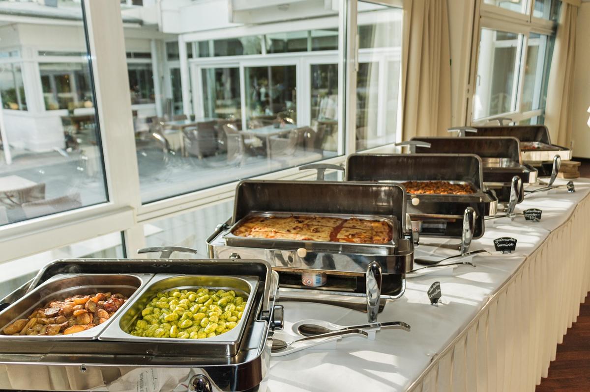 Pakistani wedding food buffet line showing grilled chicken tikka, kababs, and fresh salad
